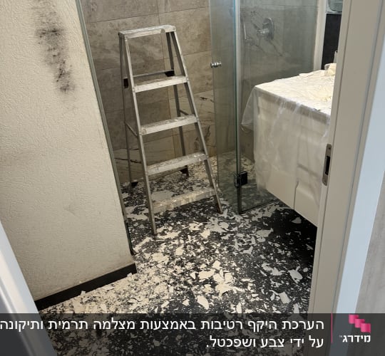 חדר אמבטיה עם סולם ופסולת בנייה על הרצפה
